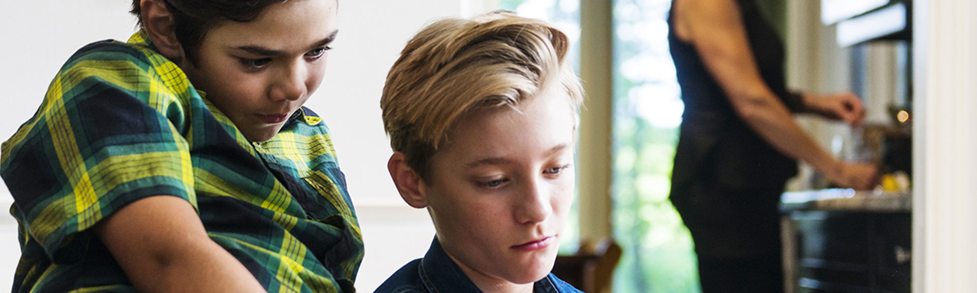 Two children looking at a phone or tablet together.