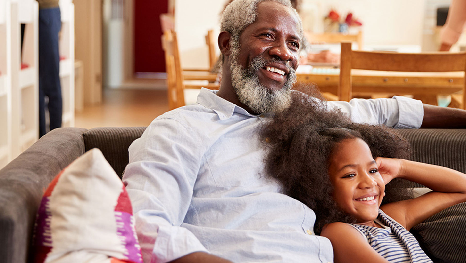 Grandfather and granddaughter watching tv together