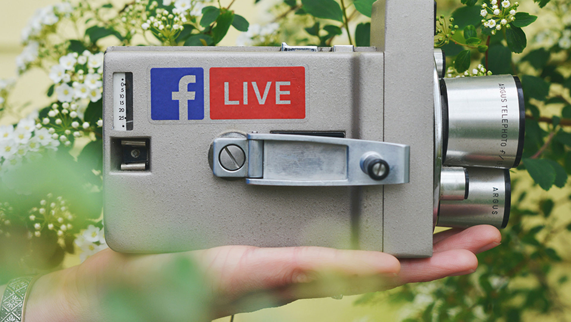 An old-style video camera with the Facebook logo and a 'live' sticker on it