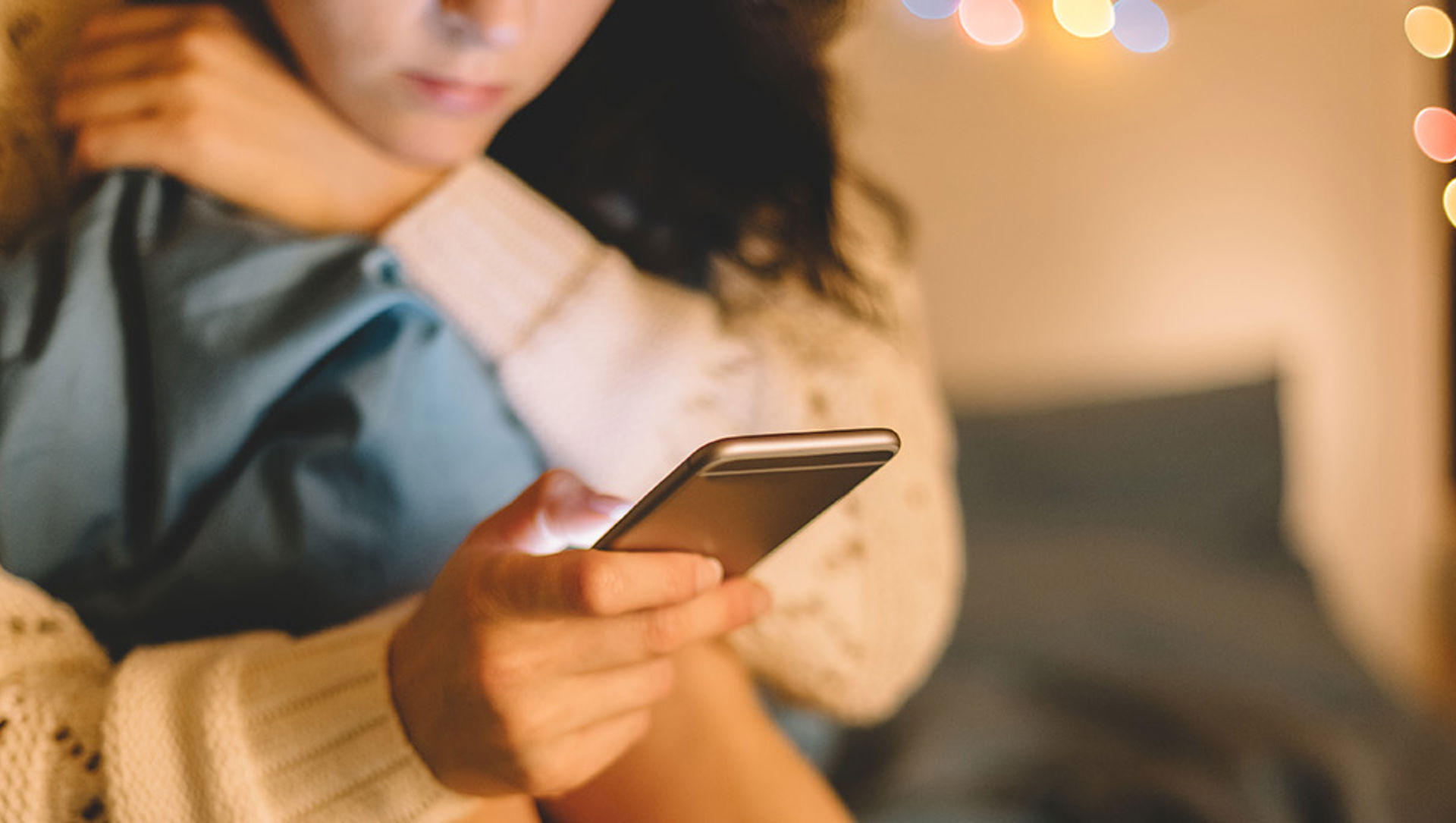 Close up of a girl on a bed using a mobile phone