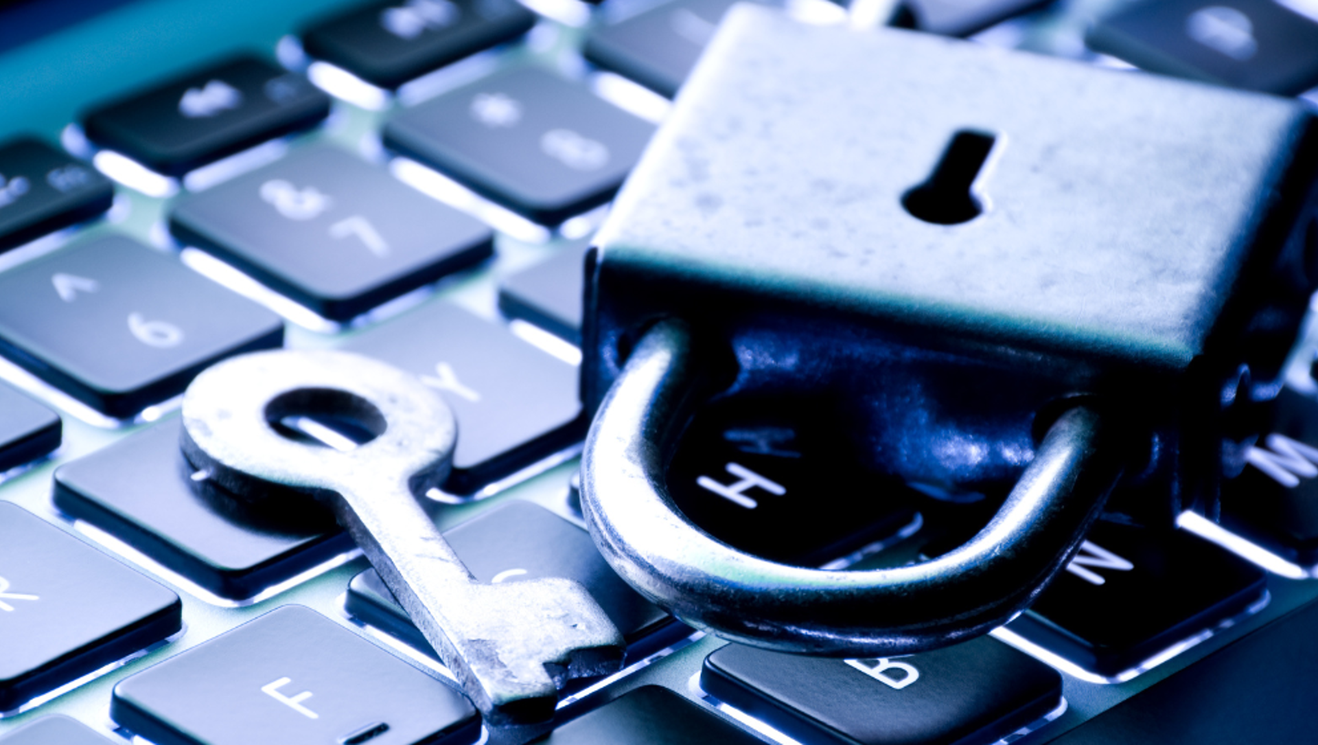 A padlock and key sitting on a laptop keyboard