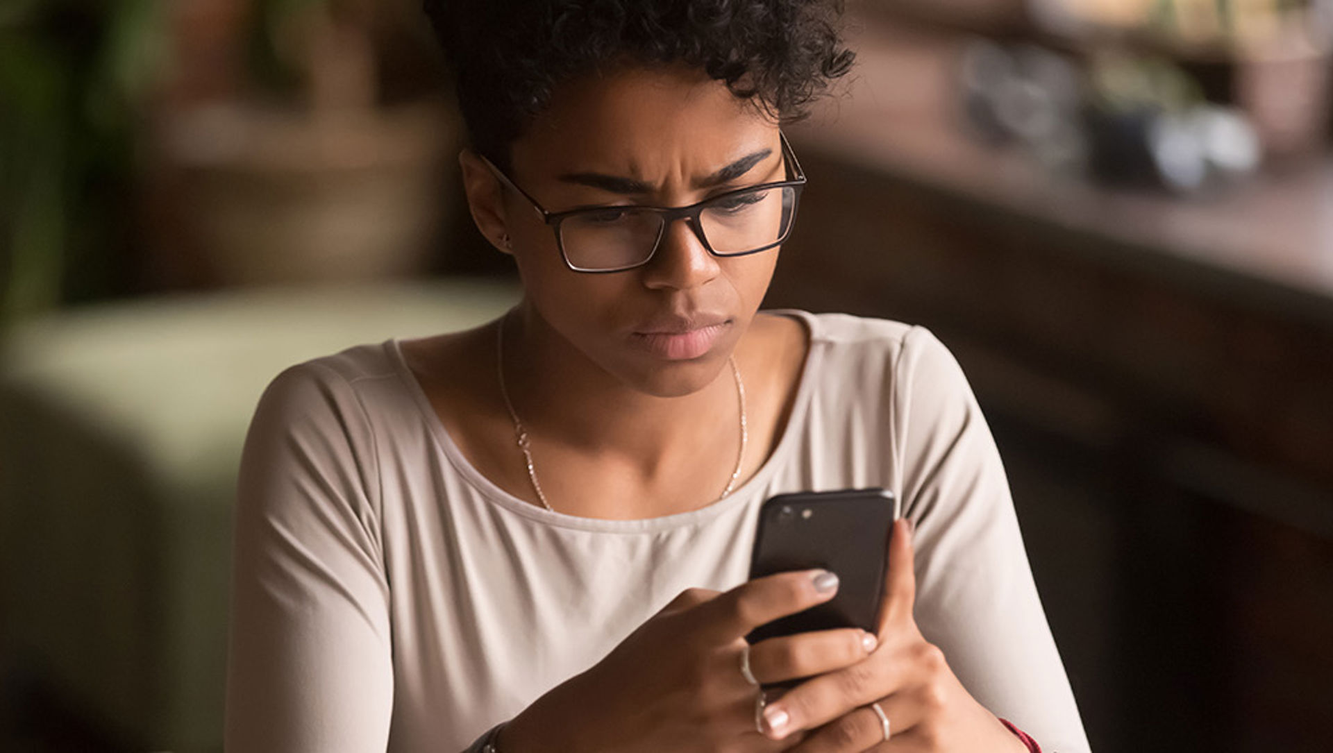 teenager using smartphone with upset look on her face.