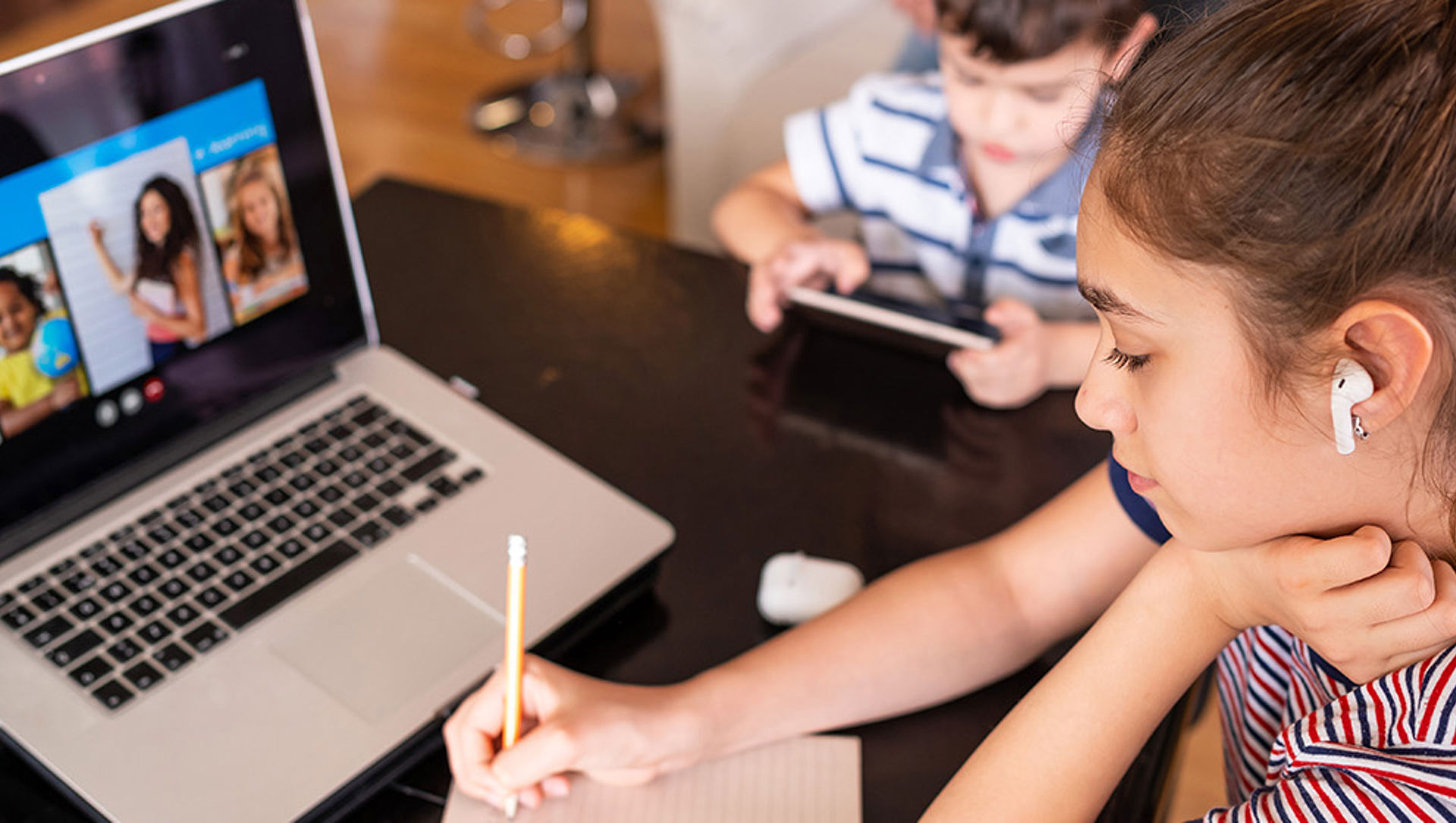 A young girl doing homework on a laptop computer