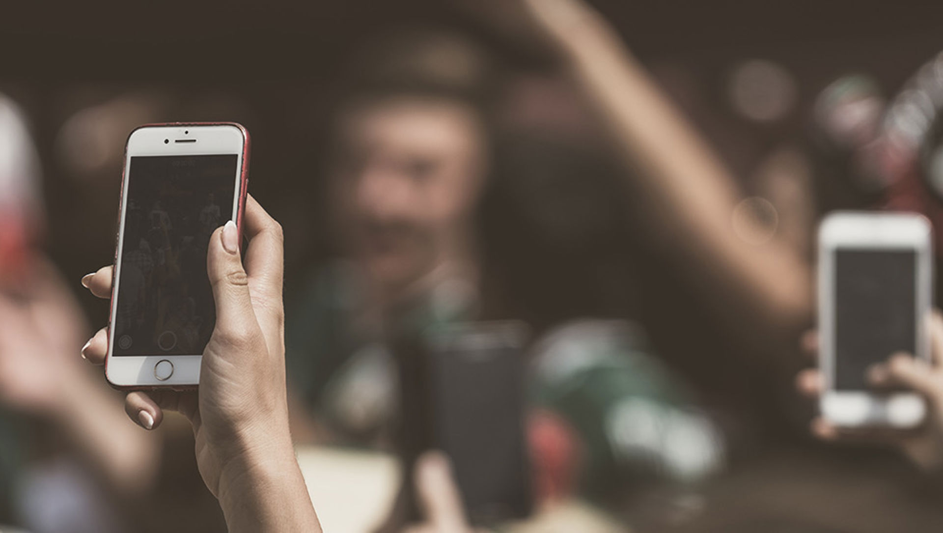 People holding smart phones in a crowded room