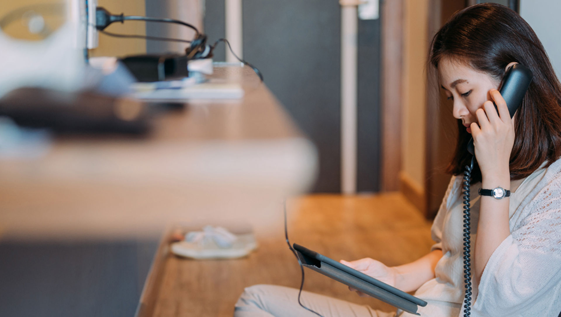 Young asian woman talking on phone, sitting on the floor