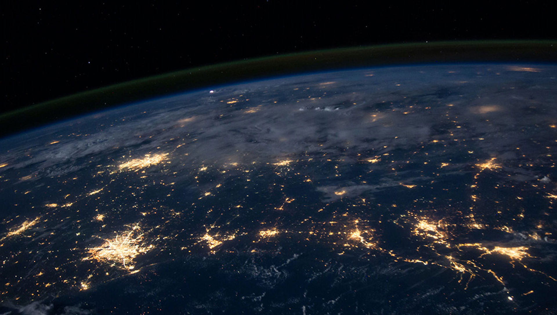 Satellite view of part of the earth at night time with cities glowing in light